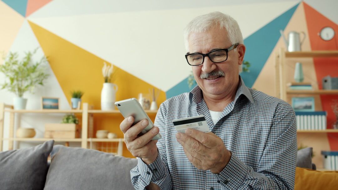 Smiling senior man holding a membership card